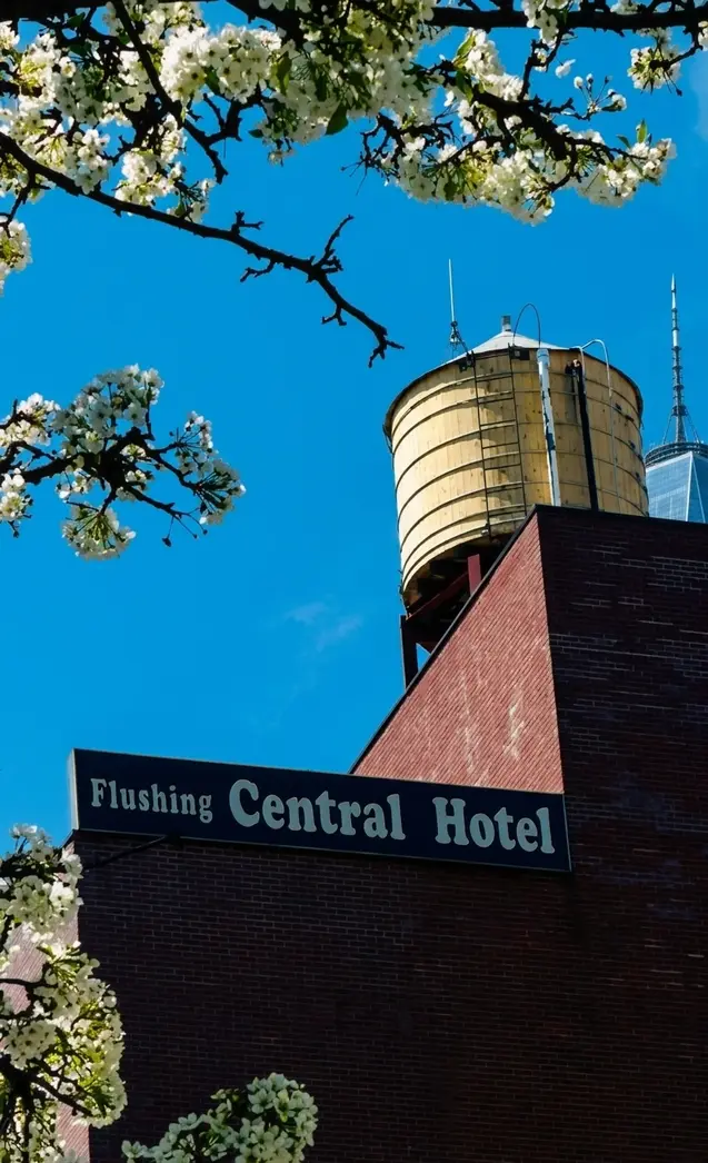 Flushing Central Hotel 88 sign with water tower and cherry blossoms